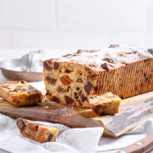 Traditional Christmas cake with fruits and nuts on white table