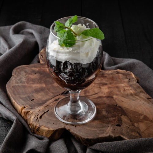 Prunes with nuts with cream and mint in a glass cup. Healthy des
